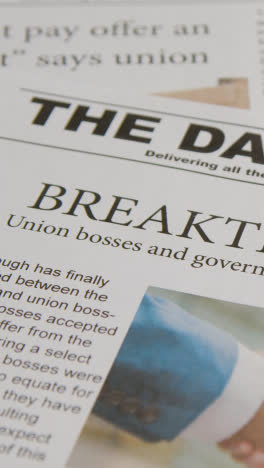 Vertical-Video-Of-Newspaper-Headline-Discussing-Strike-Negotiations-In-Trade-Union-Dispute